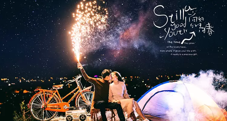 Picture of a couple kissing, next to a tent and a starry night sky