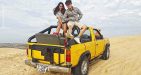 Photo of a couple sitting on the roof of a car posing for a photo at the sand dunes in Mui Ne, Phan Thiet