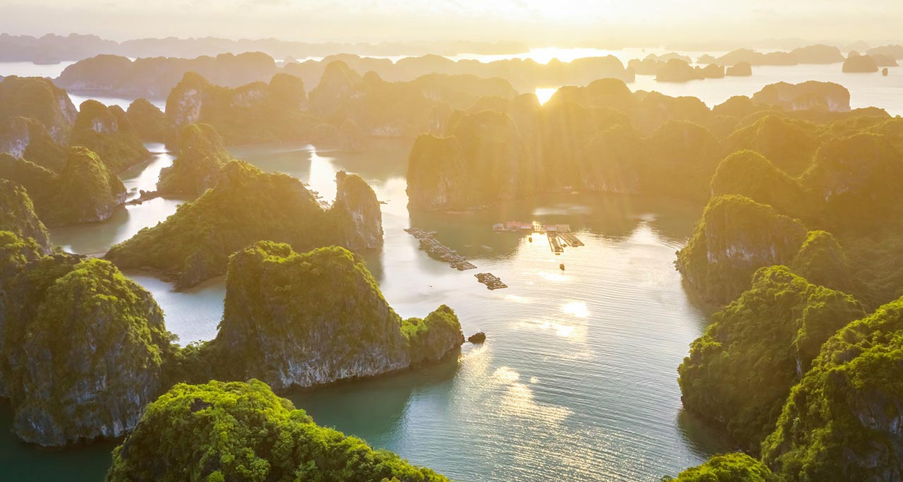 A scenic view of Ha Long Bay in Vietnam with limestone islands and boats from above