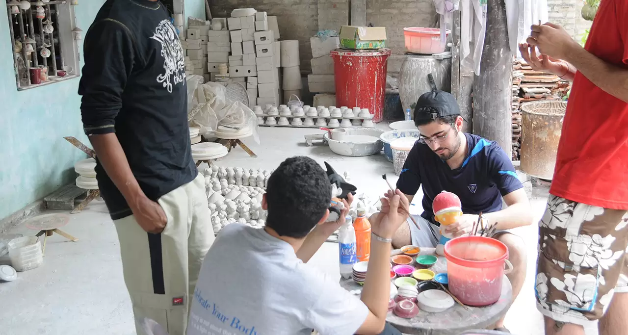 Tourists trying to decorate pottery products in Bat Trang village