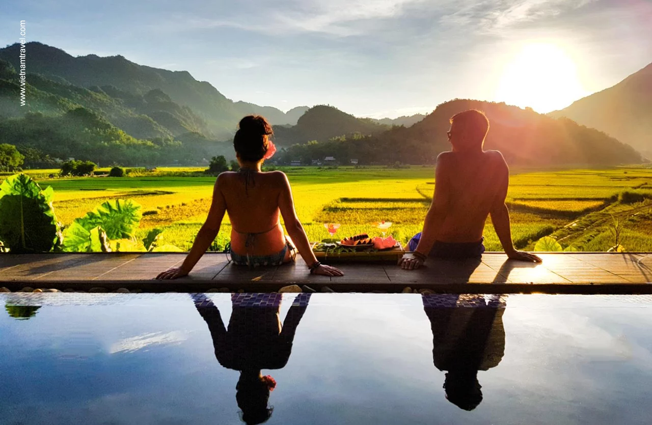 Tourists relaxing on swimming pool with panorama view to rice fields in Mai Chau