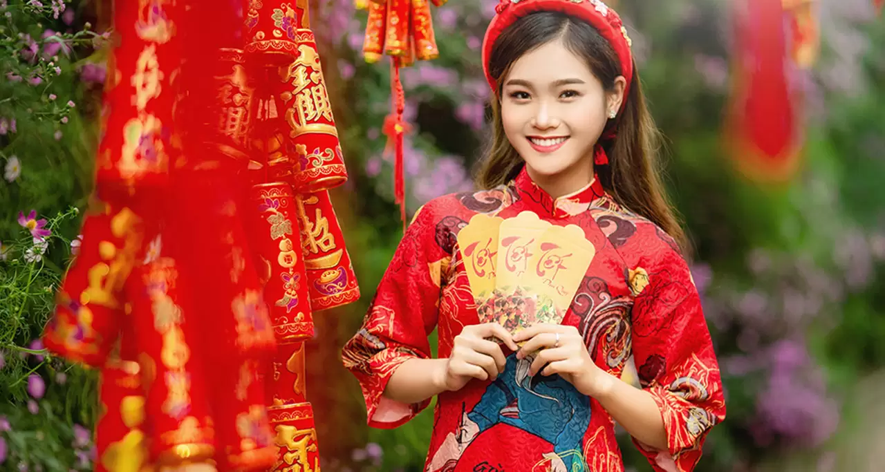 Vietnamese Girl in Traditional Dress with "red envelope" (li xi) on the Lunar New Year 
