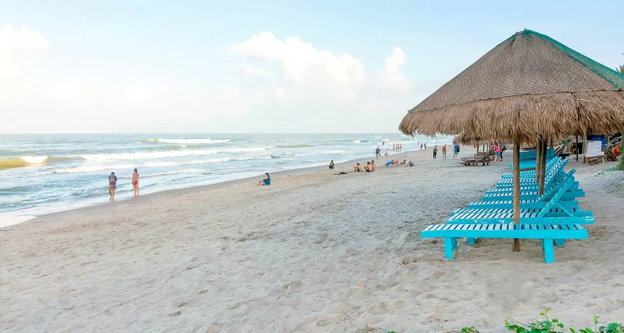 Tourists having fun on An Bang Beach, Hoi An with sedge sun tents