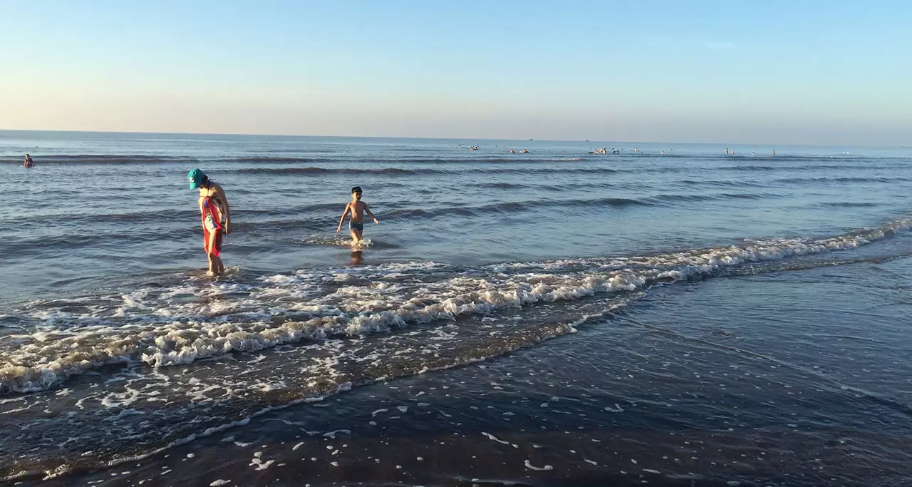 A mother and son having fun with the waves at Hai Thinh Beach, Nam Dinh