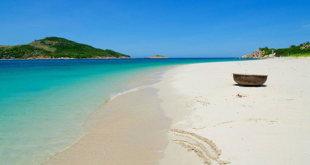 White sand, blue water and rocks at Ninh Chu Beach, Ninh Thuan