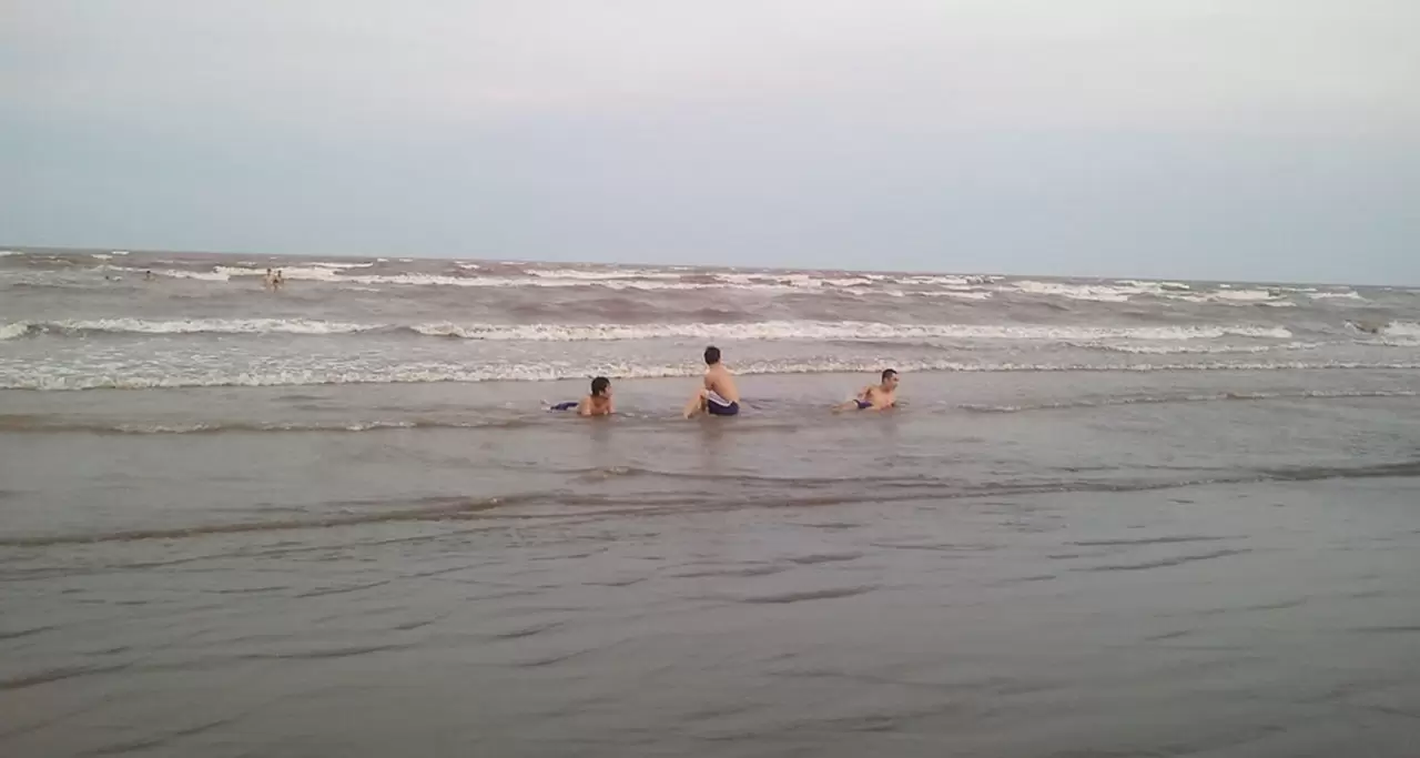Three young people enjoying the sea at Quat Lam Beach, Nam Dinh