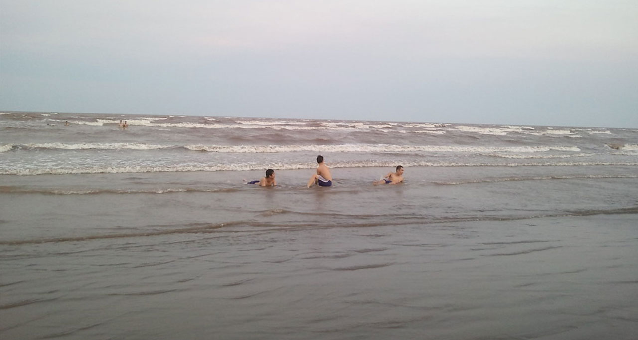 Three young people enjoying the sea at Quat Lam Beach, Nam Dinh