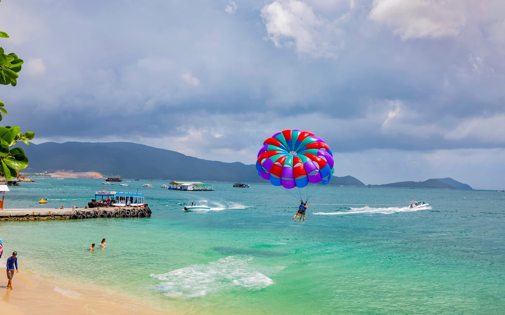 Tourist enjoy parasailing in one of the most beautiful beaches in Nha Trang.