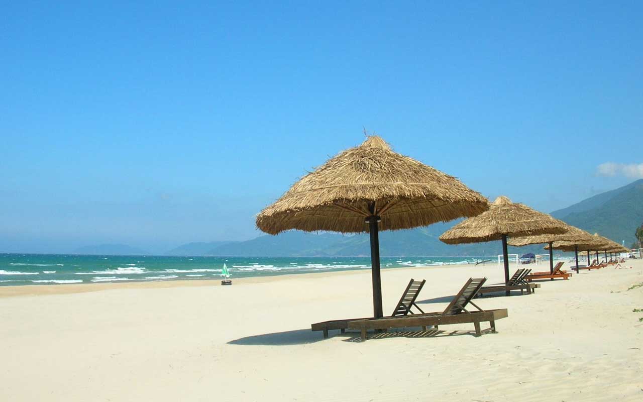 A sandy beach in Da Nang city in November with waves and parasols