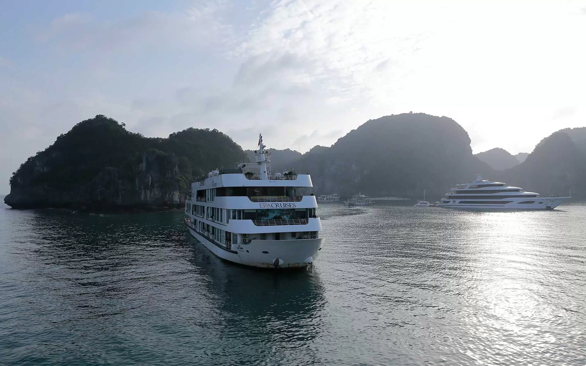Image of 2 luxury ships in Halong Bay taking guests to visit the bay in one morning
