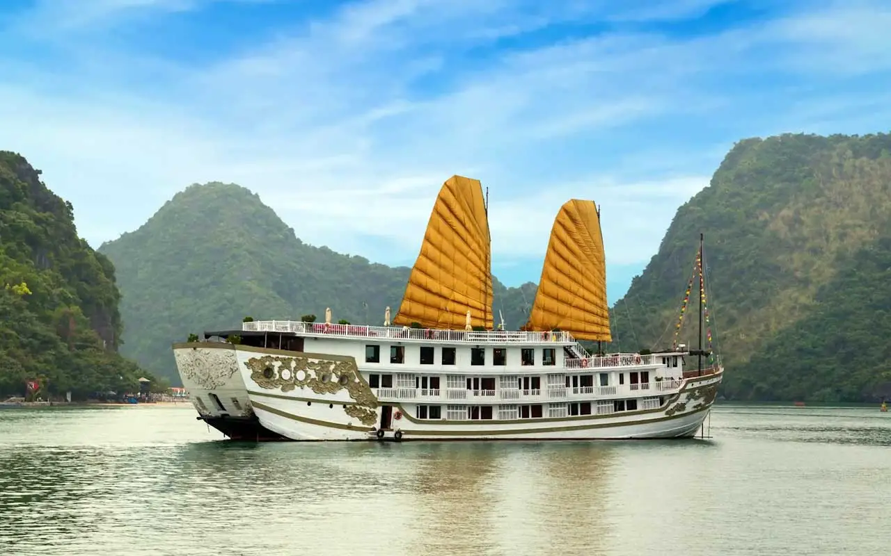 A serene view of a cruise ship sailing among the limestone islands in Halong Bay