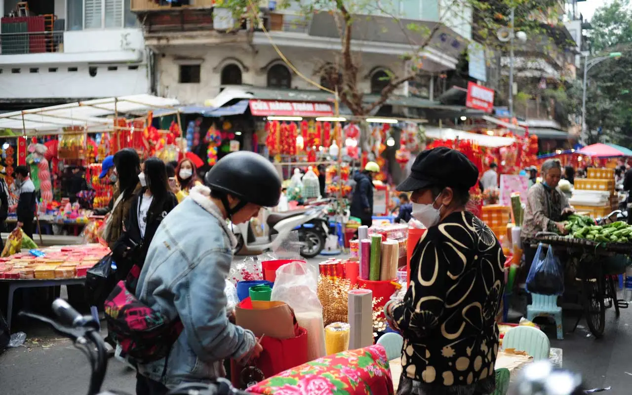 A street scene of Hanoi with colorful lanterns and mooncakes during the Mid-Autumn Festival