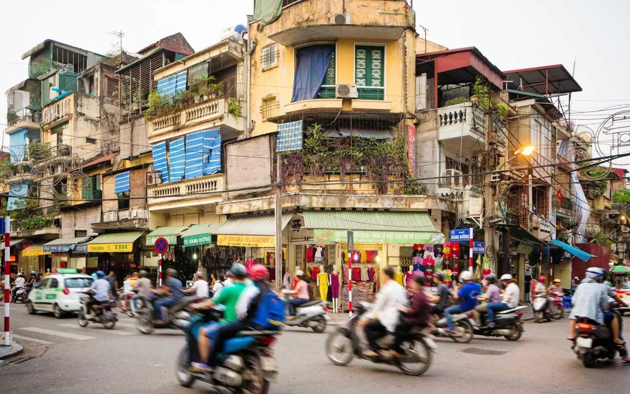 A busy street in Hanoi old quarter in November with shops and motorcycles