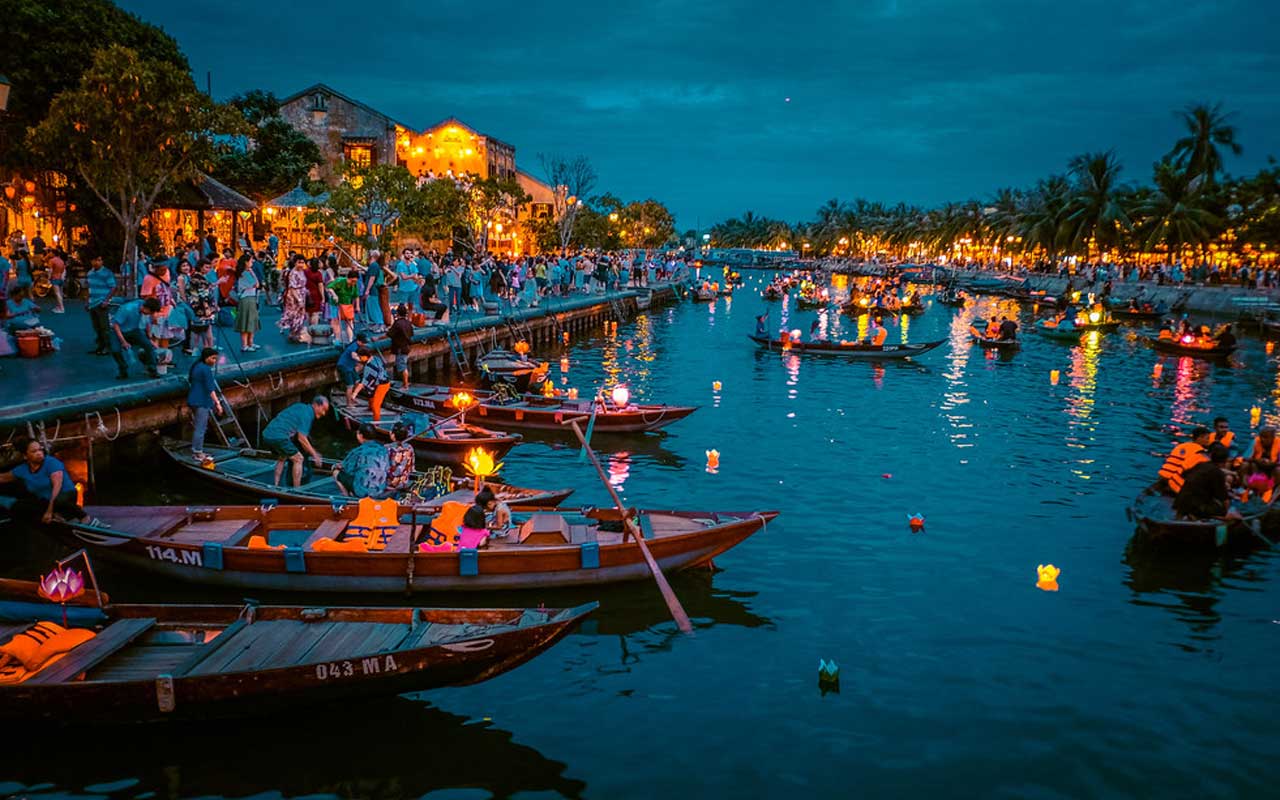  A colorful night scene of lanterns and boats along the river in Hoi An ancient town