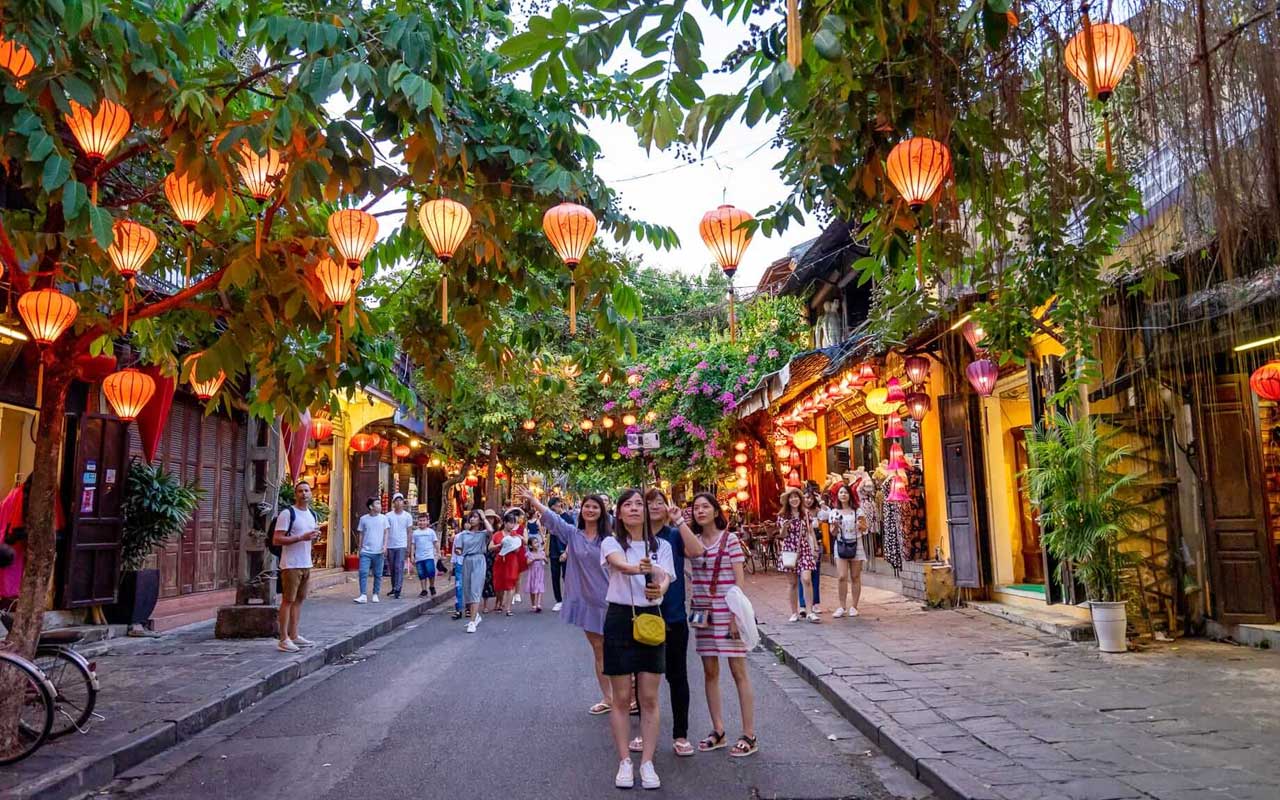 The scene of Hoi An ancient town is full of lanterns, tourists are taking pictures on the street