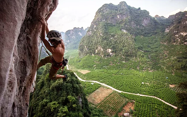 Image of a person climbing a mountain with protective gear and a helmet strap