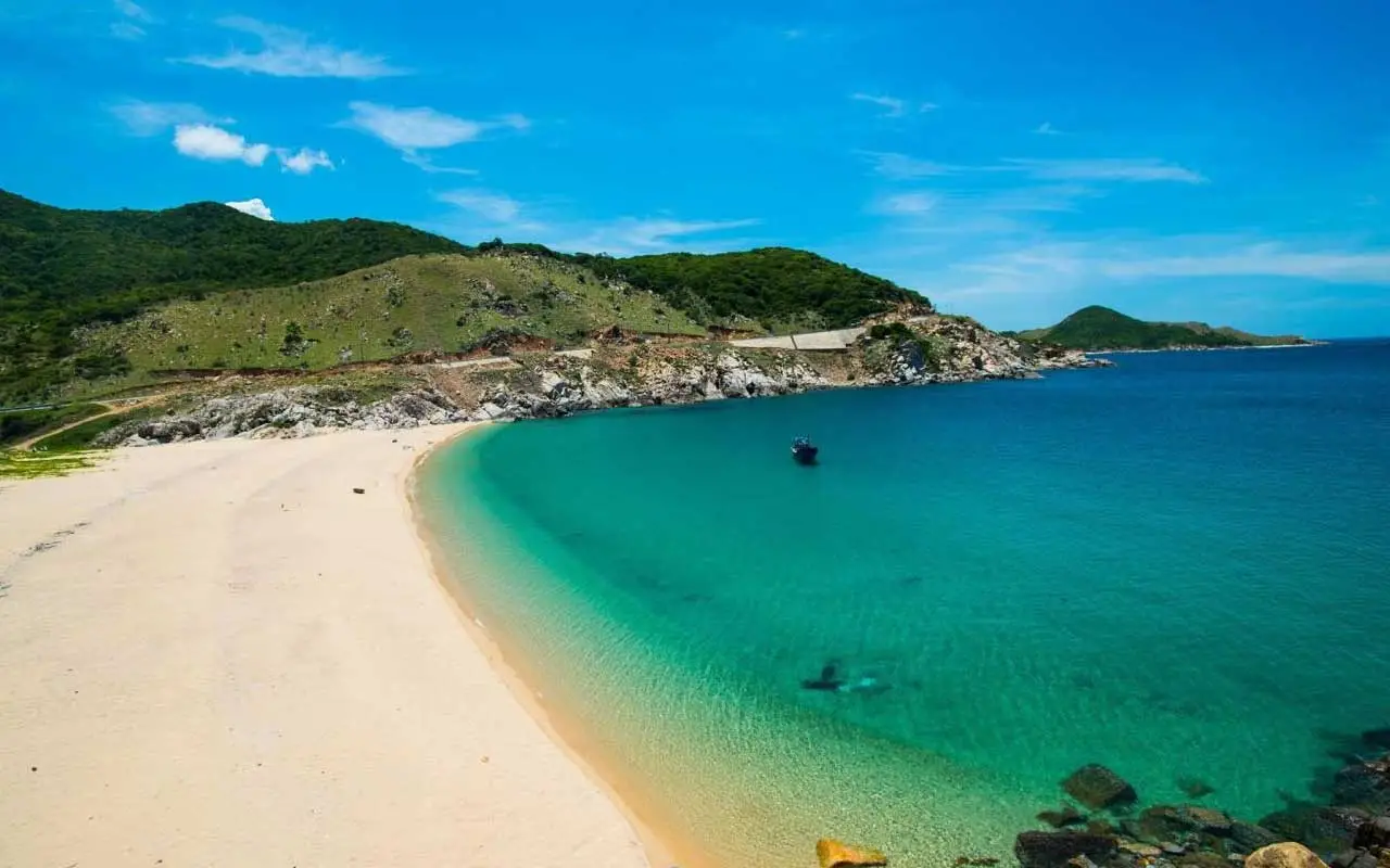 A view of a beach with blue water and white sand in Ninh Thuan