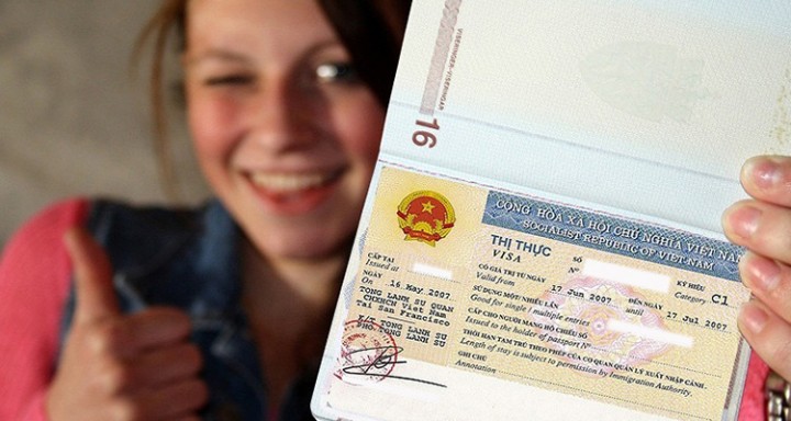 Smiling traveler giving a thumbs up while holding a passport with a Vietnam visa
Title: Vietnam Visa Requirements for Tourists