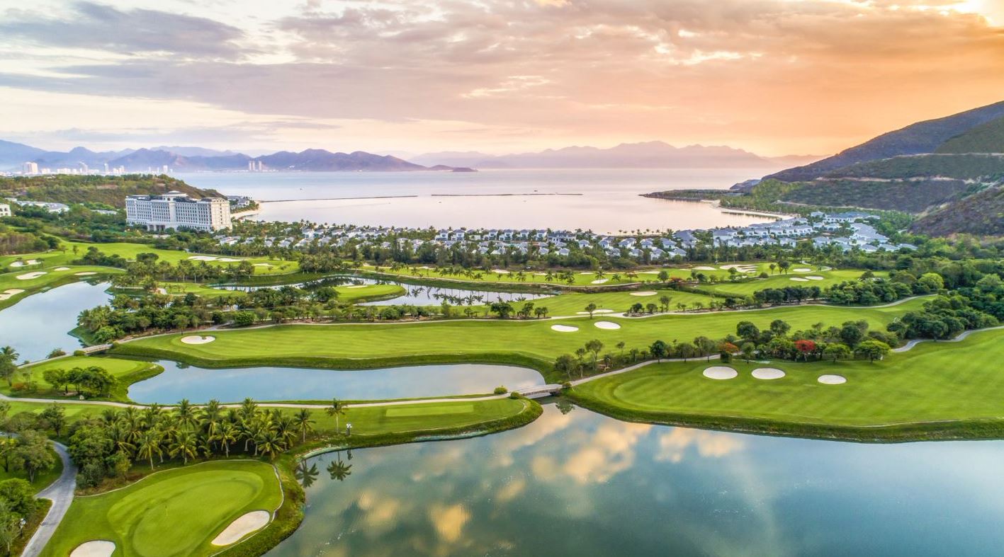 Aerial view of Vinpearl Golf Nha Trang at sunset with Nha Trang Bay in the background